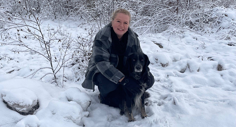 Marlene Hammargren med en hund i ett vinterlandskap. Foto.