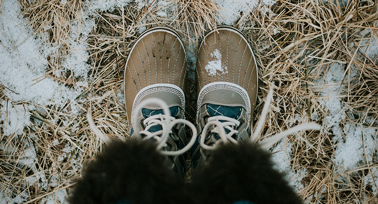 Ett barns skor ute på frostig mark. Foto