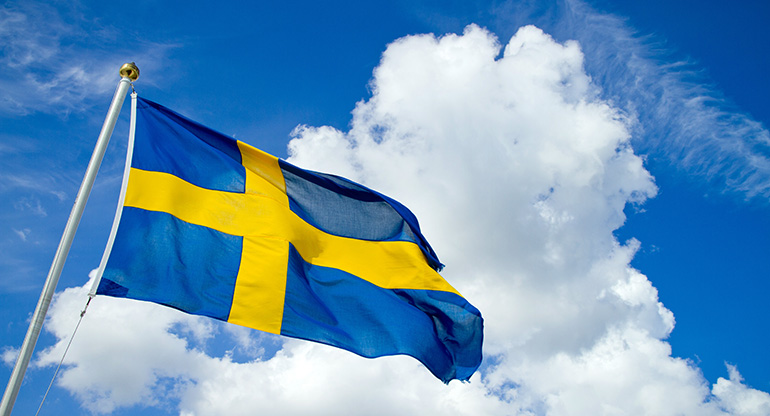 En svensk flagga på en flaggstång. Foto.