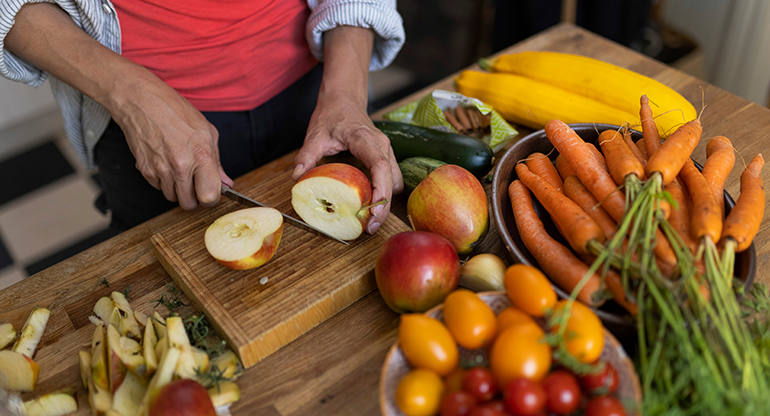 En person skär ett äpple och det ligger olika grönsaker på bänken. Foto: Melker Dahlstrand, MSB
