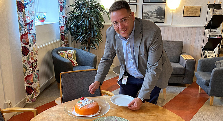 Magnus Jonsson skär upp en tårta. Foto.