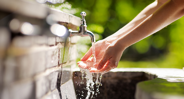 Kvinna tvättar händerna i rinnande vatten. Foto.
