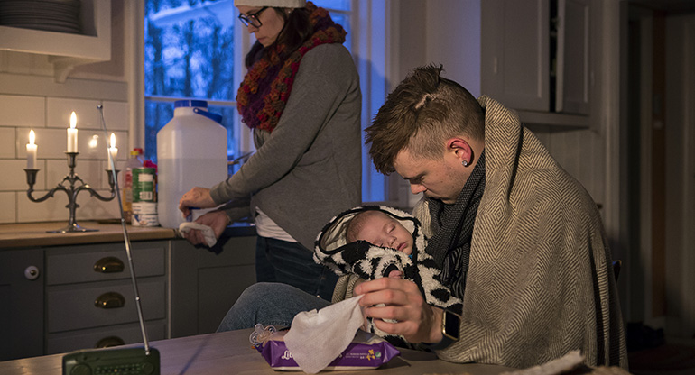 En pappa sitter med sitt barn i famnen. De har filtar på sig. Foto: Thomas Henrikson, MSB