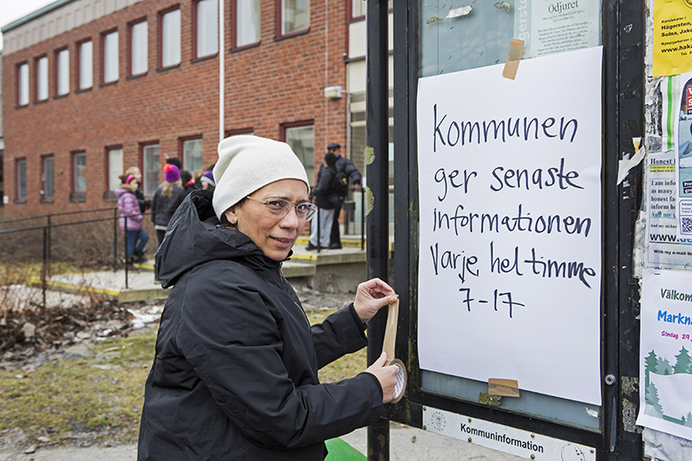 En kvinna tejpar upp information på en anslagstavla. Foto: Thomas Henrikson, MSB